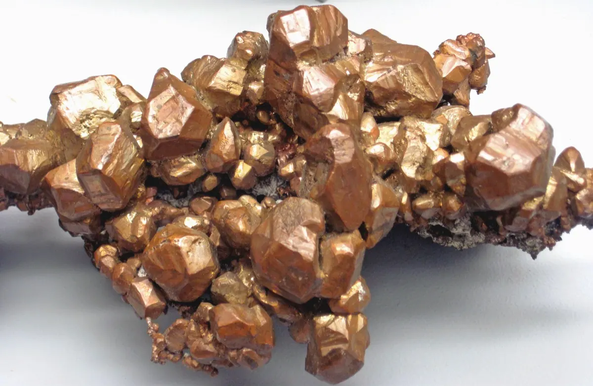 A close-up of reflective reddish-gold copper crystals